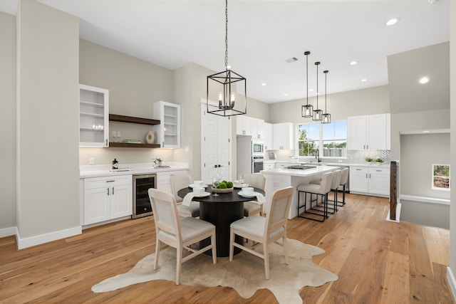 5832 Highland Sun Ln, Houston, TX 77091 - dining room with beverage cooler, light wood-type flooring, recessed lighting, a chandelier, and bar area