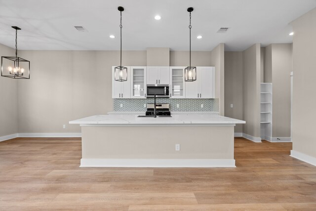 5835 Highland Sun Ln, Houston, TX 77091 - kitchen featuring stainless steel appliances, baseboards, decorative backsplash, white cabinets, and light wood finished floors