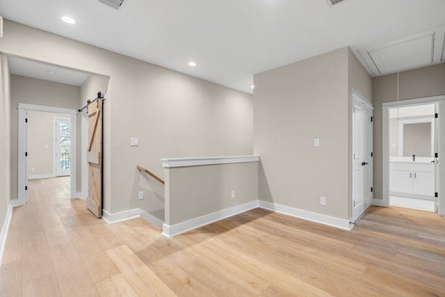 5835 Highland Sun Ln, Houston, TX 77091 - corridor with attic access, a barn door, light wood finished floors, baseboards, and recessed lighting