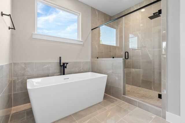 5835 Highland Sun Ln, Houston, TX 77091 - full bathroom featuring tile walls, a freestanding tub, and a stall shower