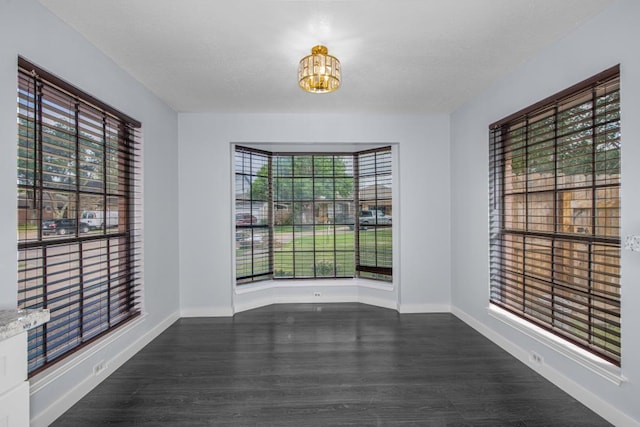 10603 Zircon Ct, Houston, TX 77099 - spare room featuring a chandelier, baseboards, and dark wood-style floors