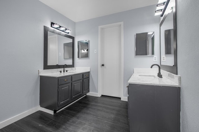 10603 Zircon Ct, Houston, TX 77099 - bathroom featuring baseboards, two vanities, and wood finished floors