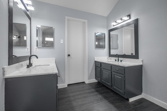 10603 Zircon Ct, Houston, TX 77099 - bathroom with two vanities, wood finished floors, baseboards, and vaulted ceiling