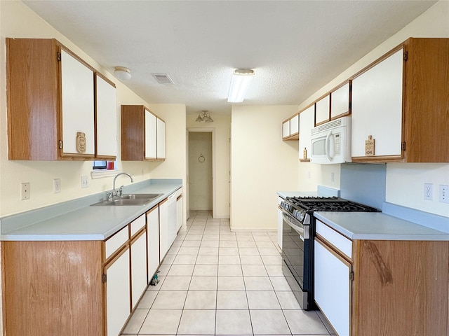8631 Mapletwist St, Houston, TX 77083 - kitchen with stainless steel gas range, a sink, white microwave, light countertops, and a textured ceiling