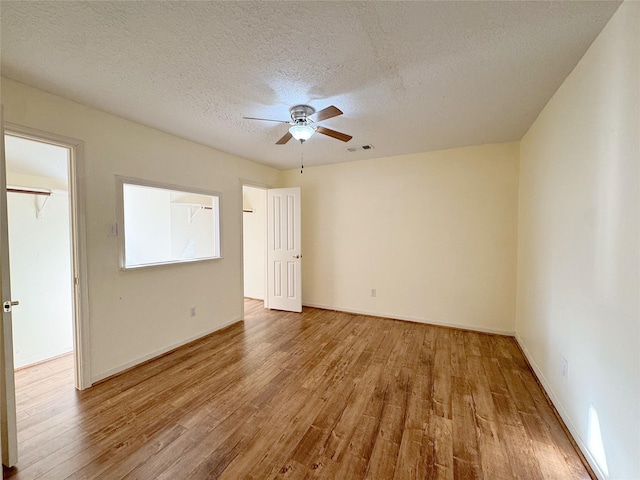 8631 Mapletwist St, Houston, TX 77083 - unfurnished bedroom featuring wood finished floors, a textured ceiling, baseboards, and a ceiling fan