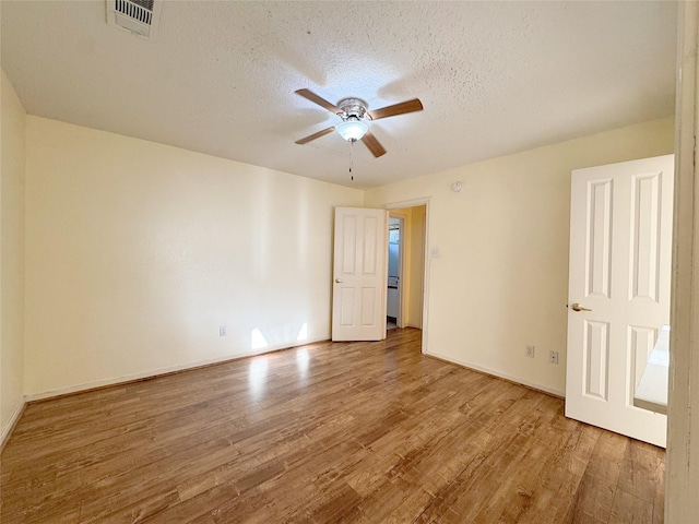 8631 Mapletwist St, Houston, TX 77083 - empty room with wood finished floors, a ceiling fan, a textured ceiling, and baseboards