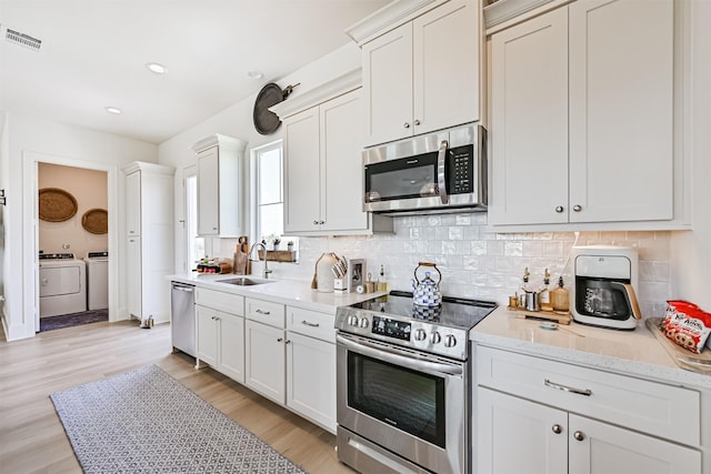 4101 5th St, Galveston, TX 77554 - kitchen with stainless steel appliances, separate washer and dryer, a sink, decorative backsplash, and recessed lighting