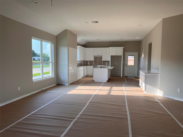 15826 Sugar Maple Ln, Santa Fe, TX 77517 - kitchen with baseboards, decorative backsplash, white cabinets, and a center island
