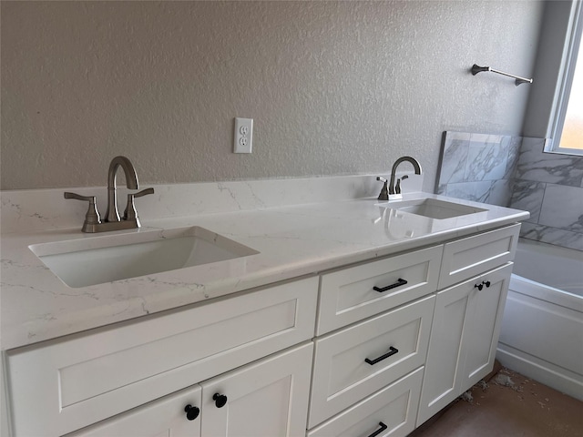 15826 Sugar Maple Ln, Santa Fe, TX 77517 - bathroom featuring double vanity, a textured wall, and a tub
