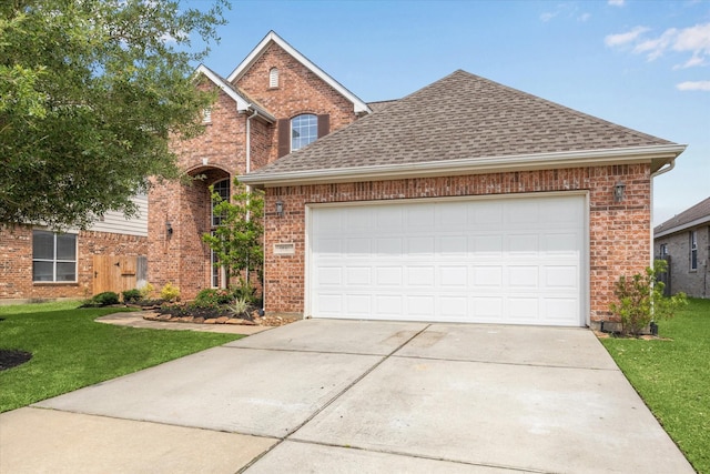9110 Kinnel Ln, Tomball, TX 77375 - traditional-style house featuring a shingled roof, concrete driveway, a front yard, an attached garage, and brick siding