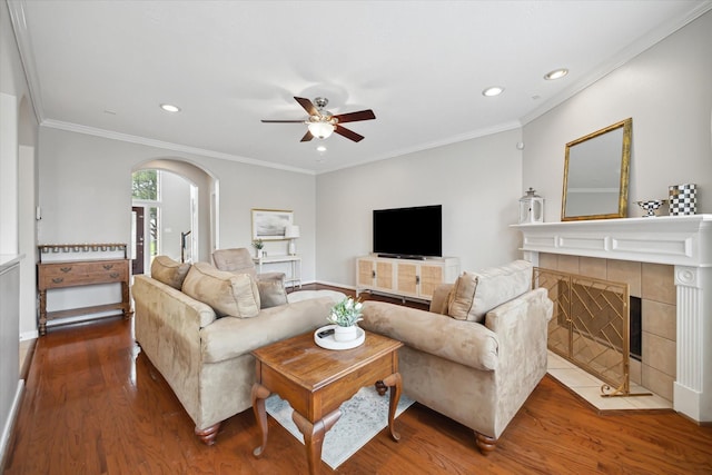 9110 Kinnel Ln, Tomball, TX 77375 - living area featuring wood finished floors, ceiling fan, arched walkways, recessed lighting, and a tiled fireplace