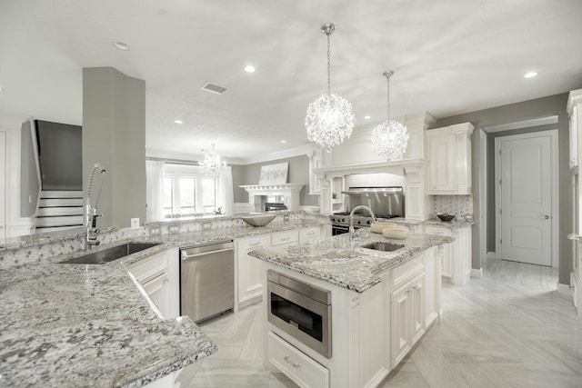 10887 Decatur St, Willis, TX 77318 - kitchen featuring appliances with stainless steel finishes, a sink, a chandelier, a spacious island, and recessed lighting
