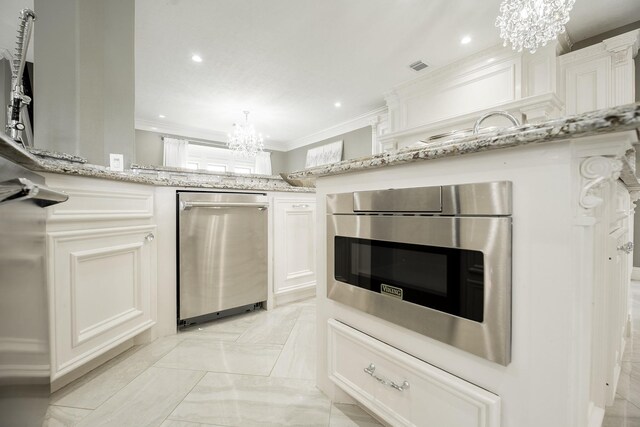 10887 Decatur St, Willis, TX 77318 - kitchen with a chandelier, crown molding, light stone countertops, white cabinets, and built in microwave