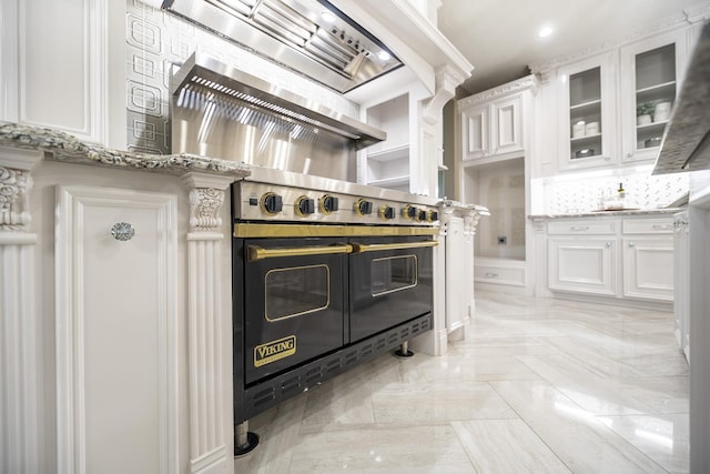 10887 Decatur St, Willis, TX 77318 - kitchen featuring white cabinets, glass insert cabinets, light stone countertops, and premium range hood