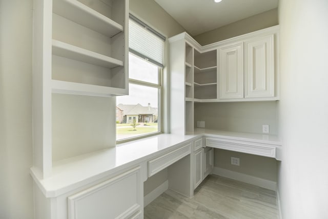 10887 Decatur St, Willis, TX 77318 - unfurnished office featuring built in desk and light wood finished floors