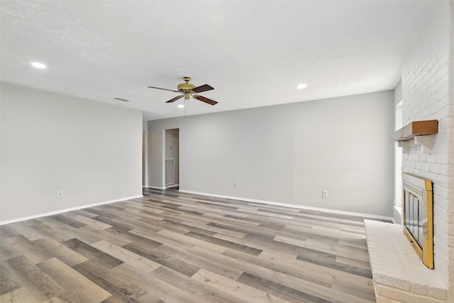10119 Peachridge Dr, Houston, TX 77070 - unfurnished living room with a ceiling fan, a brick fireplace, wood finished floors, recessed lighting, and baseboards