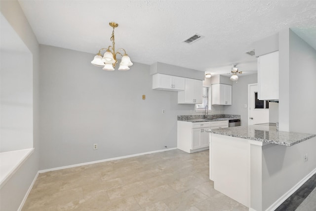 10119 Peachridge Dr, Houston, TX 77070 - kitchen with a sink, white cabinetry, light stone counters, a chandelier, and a textured ceiling