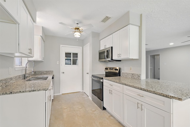 10119 Peachridge Dr, Houston, TX 77070 - kitchen featuring appliances with stainless steel finishes, a sink, a ceiling fan, white cabinets, and light stone countertops