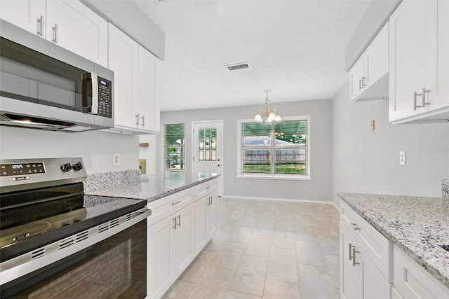 10119 Peachridge Dr, Houston, TX 77070 - kitchen featuring appliances with stainless steel finishes, white cabinets, light stone countertops, and a chandelier