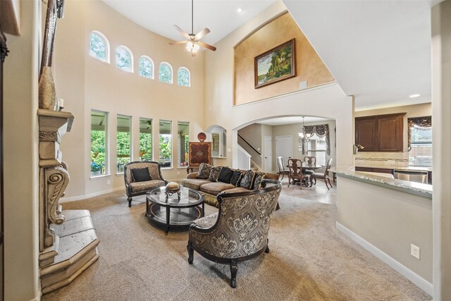 13803 Oak Fair Bnd, Cypress, TX 77429 - living room featuring arched walkways, light colored carpet, a chandelier, stairway, and a towering ceiling