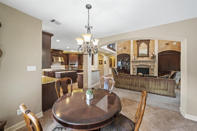 13803 Oak Fair Bnd, Cypress, TX 77429 - dining area featuring arched walkways, baseboards, a chandelier, recessed lighting, and a fireplace