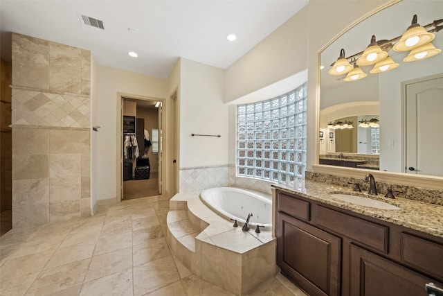 13803 Oak Fair Bnd, Cypress, TX 77429 - bathroom featuring vanity, a jetted tub, tile patterned floors, a spacious closet, and a chandelier