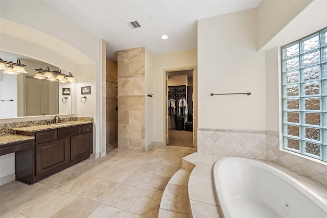 13803 Oak Fair Bnd, Cypress, TX 77429 - bathroom with a tub with jets, vanity, a walk in shower, tile patterned floors, and a spacious closet