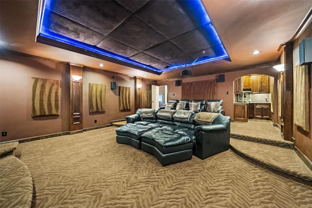 13803 Oak Fair Bnd, Cypress, TX 77429 - home theater featuring a tray ceiling, carpet floors, arched walkways, and baseboards