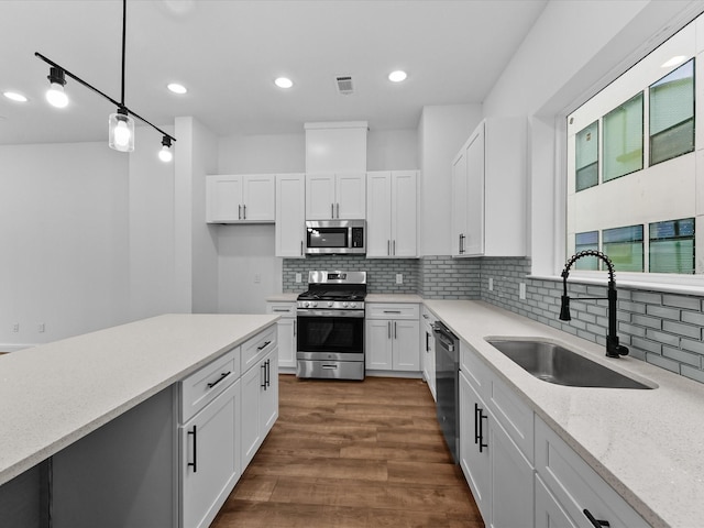 2318 Mcilhenny St, Houston, TX 77004 - kitchen featuring stainless steel appliances, a sink, white cabinets, backsplash, and recessed lighting