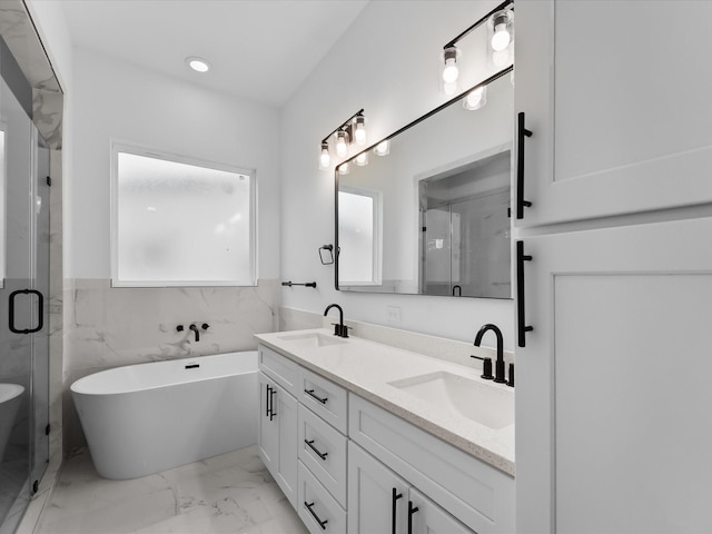 2318 Mcilhenny St, Houston, TX 77004 - full bath with double vanity, marble look tile flooring, a freestanding tub, a shower stall, and recessed lighting