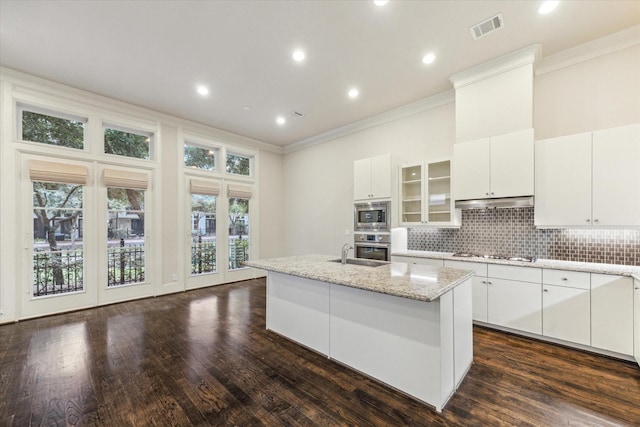 1701 Wrenwood Lks, Houston, TX 77043 - kitchen with ornamental molding, appliances with stainless steel finishes, a center island with sink, plenty of natural light, and decorative backsplash