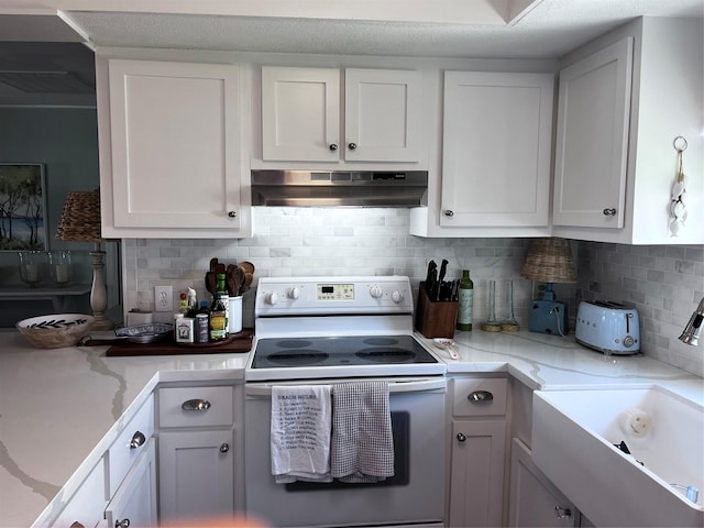 16627 Bermuda Way, Jamaica Beach, TX 77554 - kitchen with white range with electric stovetop, under cabinet range hood, a sink, and white cabinets