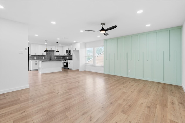 8707 Wind Side Dr, Houston, TX 77040 - unfurnished living room with a ceiling fan, light wood-style floors, a sink, and recessed lighting