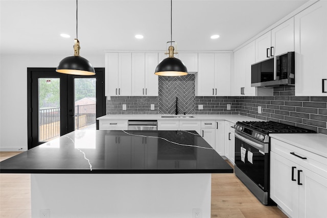 8707 Wind Side Dr, Houston, TX 77040 - kitchen with stainless steel appliances, a sink, backsplash, white cabinetry, and light wood finished floors