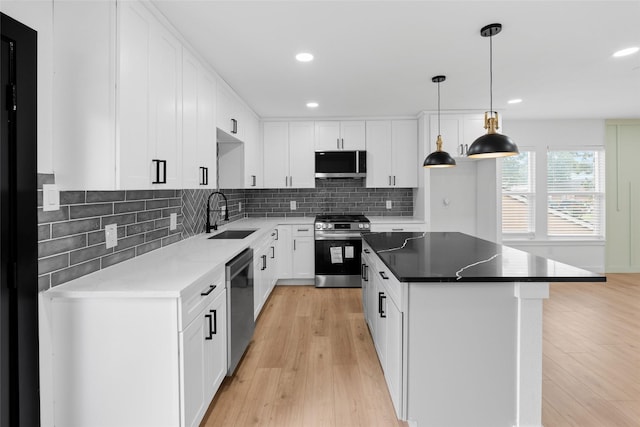 8707 Wind Side Dr, Houston, TX 77040 - kitchen featuring stainless steel appliances, a sink, light wood-style floors, tasteful backsplash, and recessed lighting