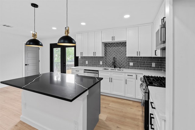 8707 Wind Side Dr, Houston, TX 77040 - kitchen with appliances with stainless steel finishes, a sink, a center island, light wood finished floors, and recessed lighting