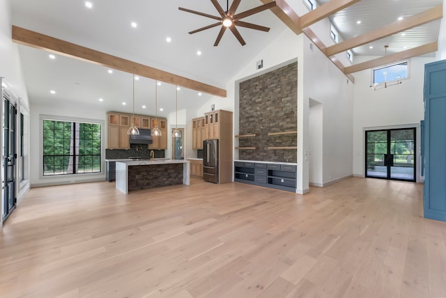 15086 Dewberry Ln, Conroe, TX 77302 - unfurnished living room featuring high vaulted ceiling, beamed ceiling, a ceiling fan, light wood-style floors, and plenty of natural light