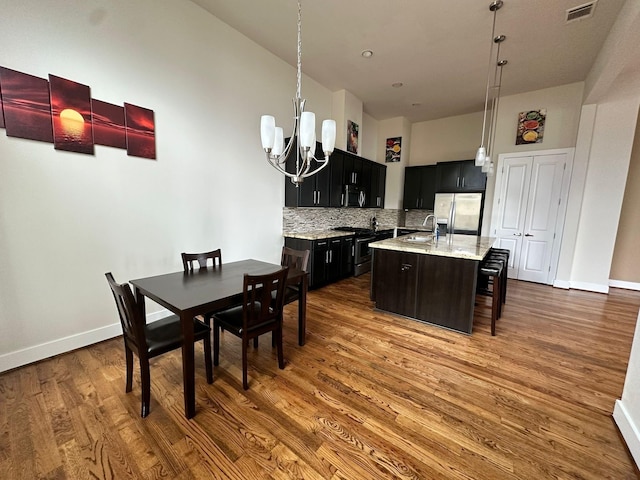 1613 Bonner St, Houston, TX 77007 - dining room featuring a chandelier, dark wood-type flooring, baseboards, and a towering ceiling