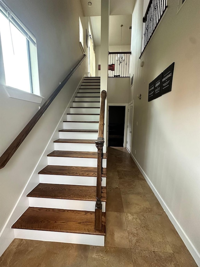 1613 Bonner St, Houston, TX 77007 - staircase with baseboards, stone finish floors, and a towering ceiling