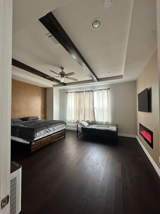 1613 Bonner St, Houston, TX 77007 - bedroom featuring a glass covered fireplace, wood finished floors, baseboards, beam ceiling, and ceiling fan