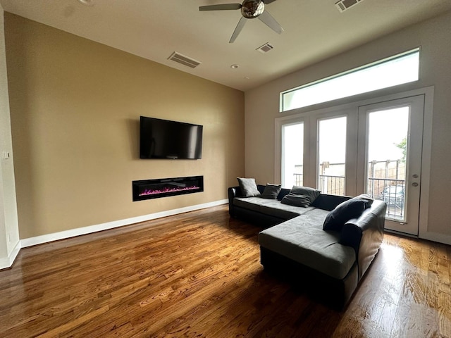 1613 Bonner St, Houston, TX 77007 - living area featuring wood finished floors, a glass covered fireplace, ceiling fan, and baseboards