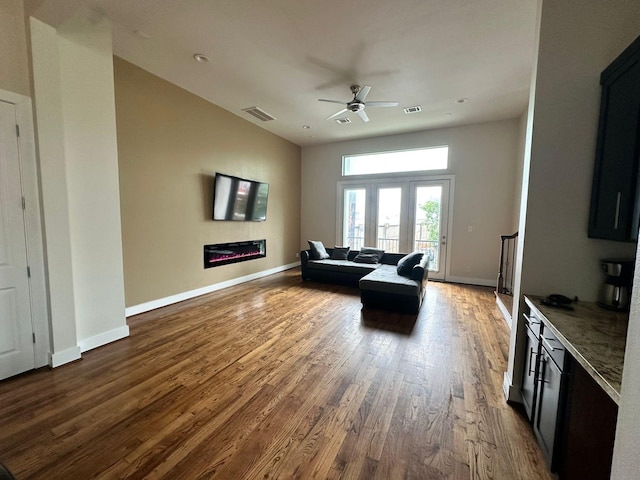 1613 Bonner St, Houston, TX 77007 - living area with wood finished floors, ceiling fan, a glass covered fireplace, and baseboards