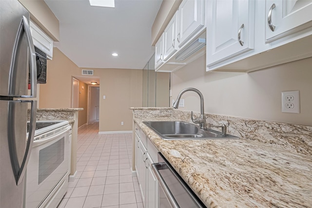 2110 Wilcrest Dr Unit 236, Houston, TX 77042 - kitchen featuring a sink, appliances with stainless steel finishes, light tile patterned floors, white cabinets, and recessed lighting