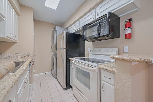 2110 Wilcrest Dr Unit 236, Houston, TX 77042 - kitchen featuring white electric range, black microwave, stacked washer / dryer, light tile patterned floors, and white cabinets