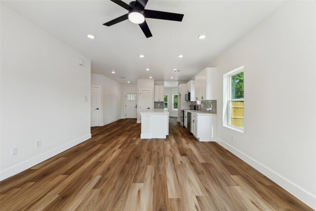 3700 Avenue S, Santa Fe, TX 77510 - kitchen featuring a ceiling fan, white cabinetry, a center island, light countertops, and baseboards