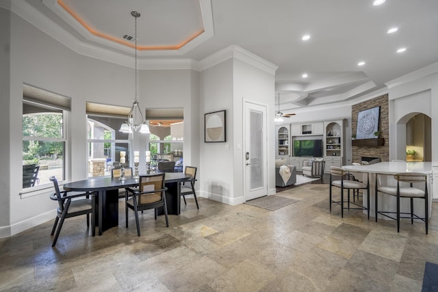 12911 Mossy Shr, Tomball, TX 77375 - dining space featuring a raised ceiling, ornamental molding, baseboards, a stone fireplace, and recessed lighting