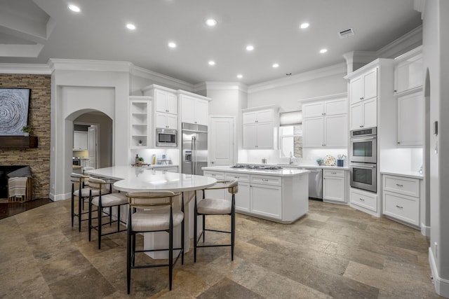 12911 Mossy Shr, Tomball, TX 77375 - kitchen featuring built in appliances, open shelves, arched walkways, a kitchen island, and ornamental molding