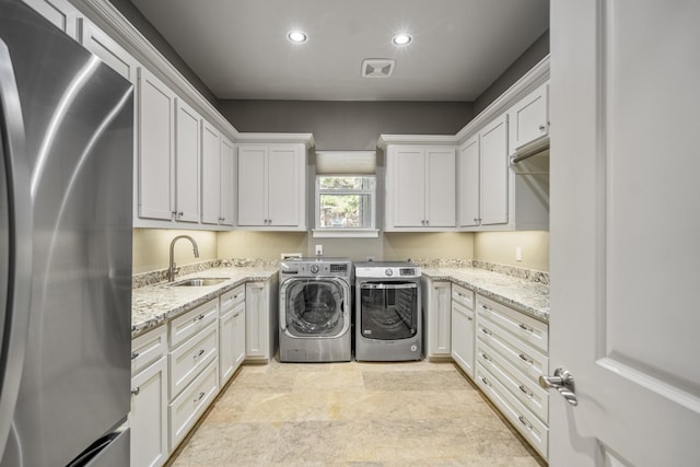 12911 Mossy Shr, Tomball, TX 77375 - washroom with washing machine and clothes dryer, cabinet space, recessed lighting, and stone finish flooring