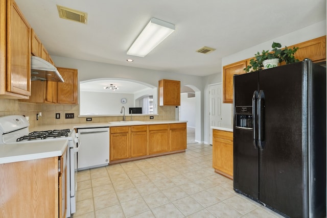 19710 Ringwald Ct, Spring, TX 77379 - kitchen featuring white appliances, a sink, arched walkways, light countertops, and backsplash