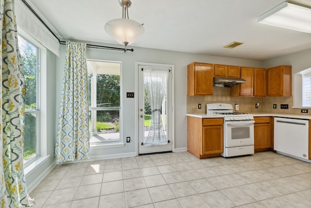 19710 Ringwald Ct, Spring, TX 77379 - kitchen with white appliances, under cabinet range hood, light countertops, and healthy amount of natural light